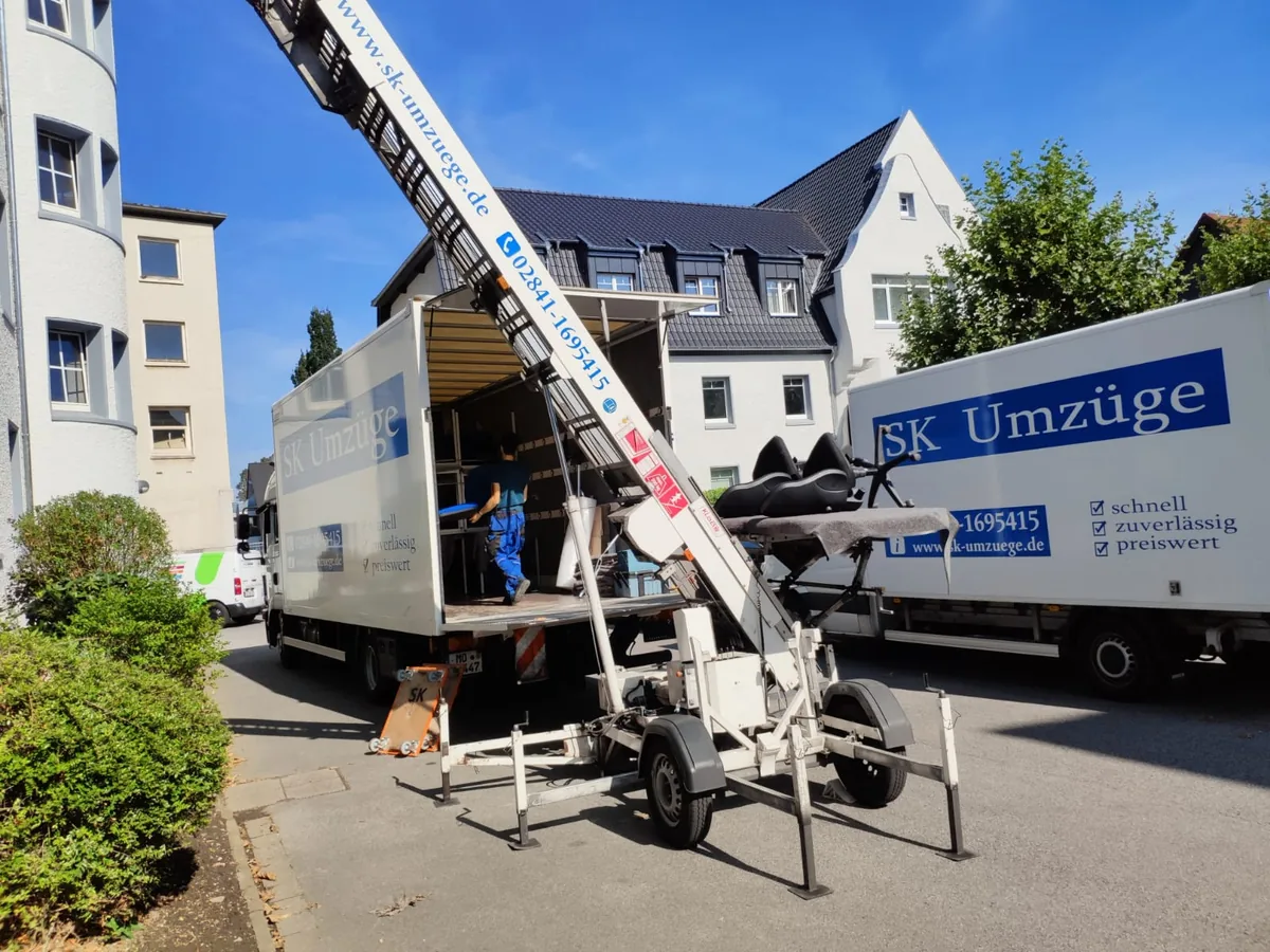 SK-Umzüge Team bei einem Umzug mit Möbellift und Umzugswagen